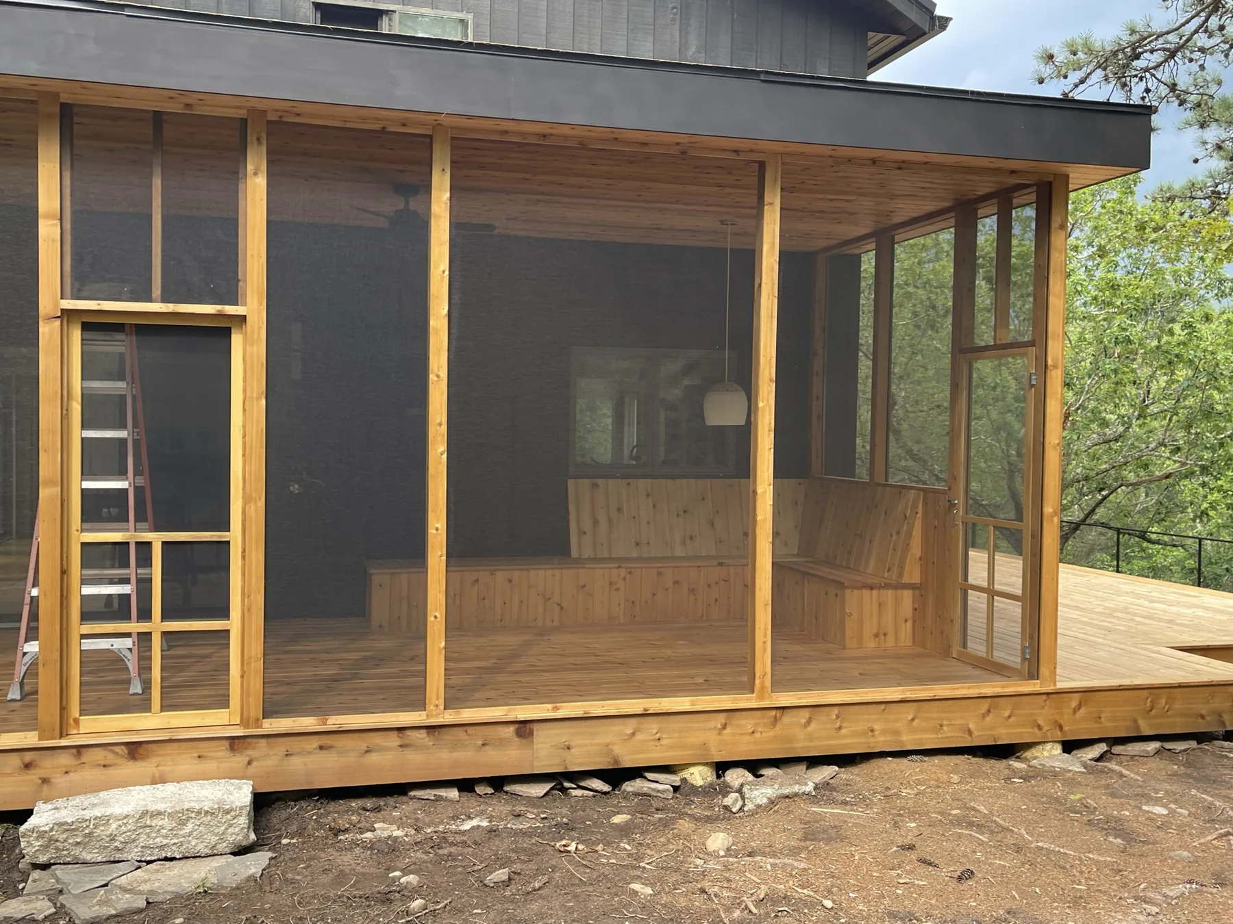 Cedar-framed screened porch with full-height screen panels and a screen door opening onto the new deck