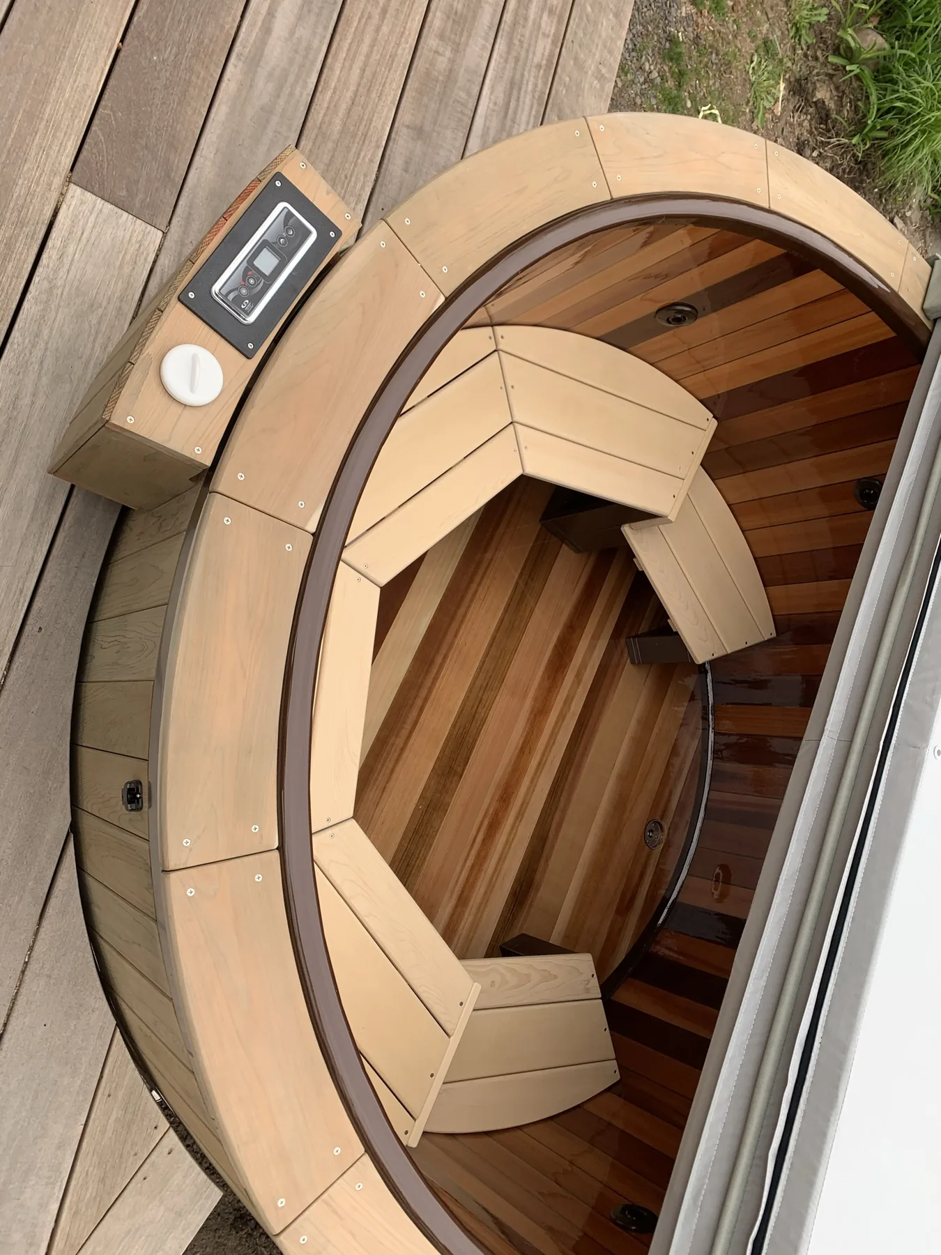 Overhead view of a cedar-clad hot tub with contoured bench seating open on an ipe deck